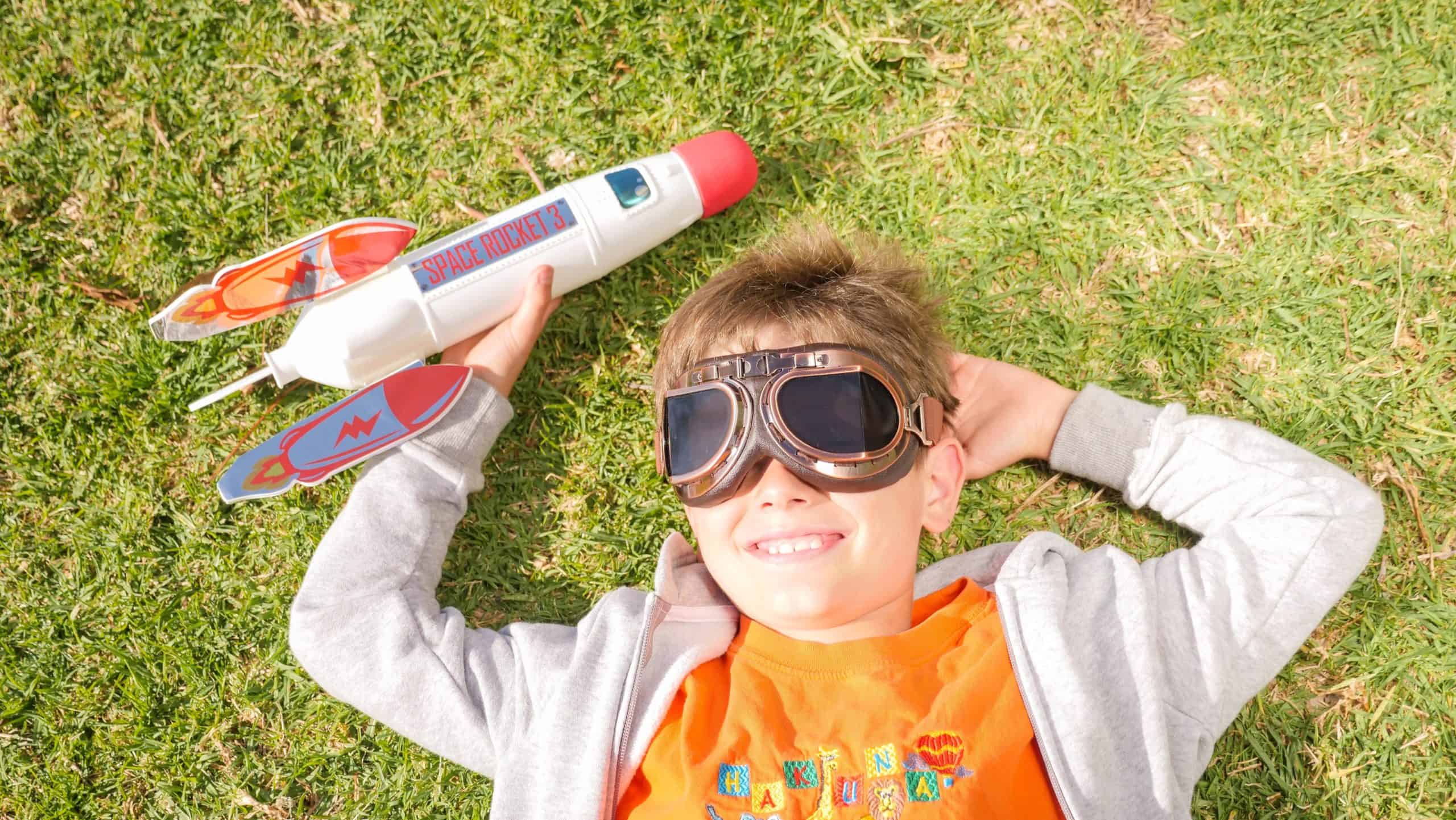 Junge mit Spielzeugrakete im Garten, Spaß und Abenteuer.